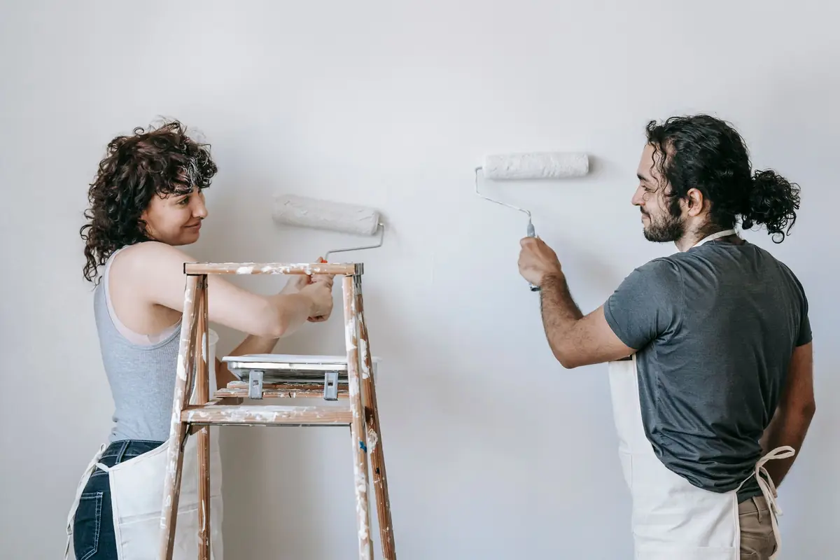 People painting a wall together